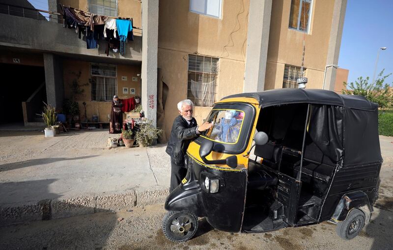 Syrian refugee Ahmad al-Khatib cleans his auto rickshaw as his wife Ilham Mohammad watches, outside their home in Cairo, Egypt. Reuters