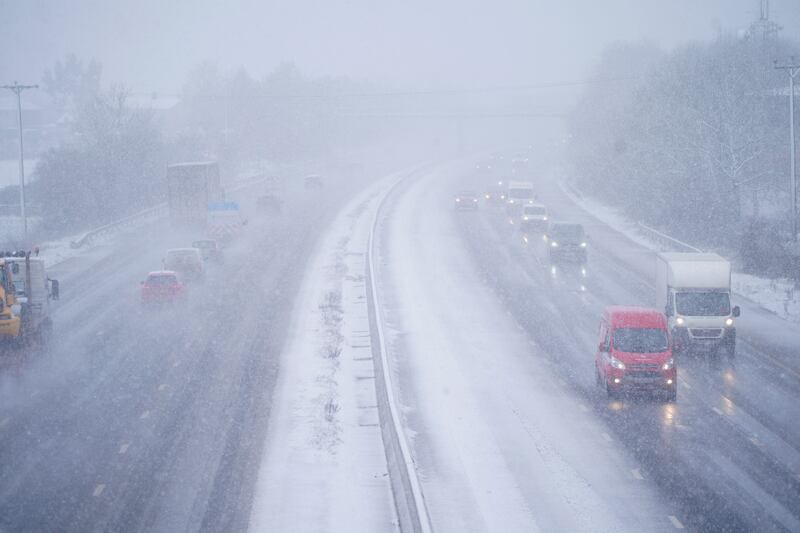 Cars driving through snow on the M5 motorway near Taunton. PA