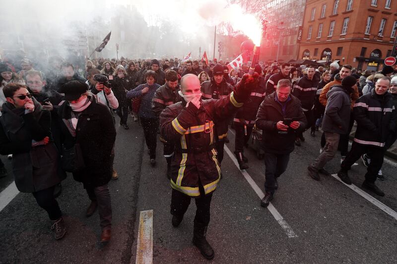 A firefighter lights a flare during demonstrations in Toulouse. EPA