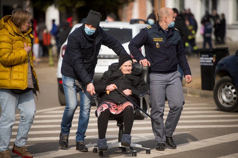 Border police at the Romanian-Ukrainian border push an elderly woman in an office chair after she fled the conflict in neighbouring Ukraine. AP