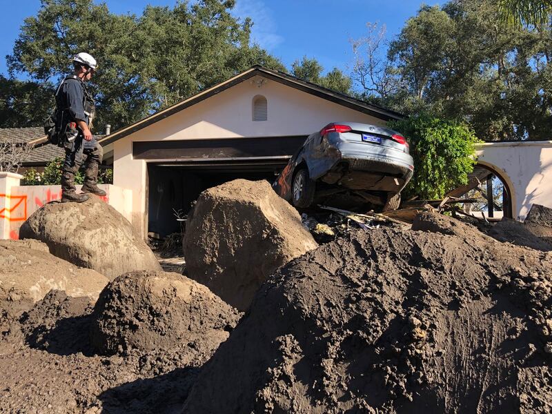 A member of the Fresno Fire Department searches homes in Montecito, California, following a deadly mudslide that occurred in January 2018. AP