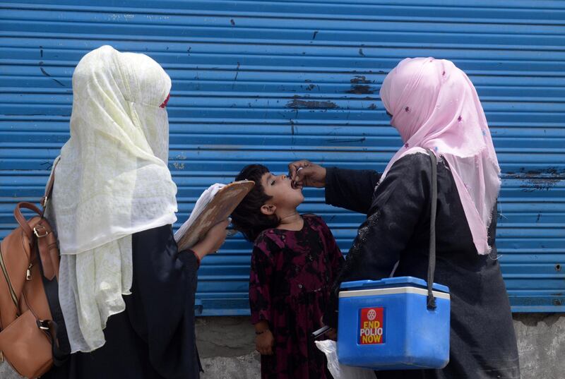 A Pakistani health worker administers polio vaccine drops to an Afghan refugee child during a polio vaccination campaign in Lahore on June 19, 2019. (Photo by ARIF ALI / AFP)