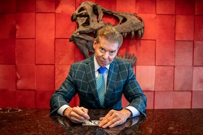 Vince McMahon signing a billion dollar bill as part of the WWE & Goldin Partner auction of 'One-of-One Vince McMahon “Billionaire Bucks” T-Shirt & Signed Billion Dollar Bill'. AP Photo