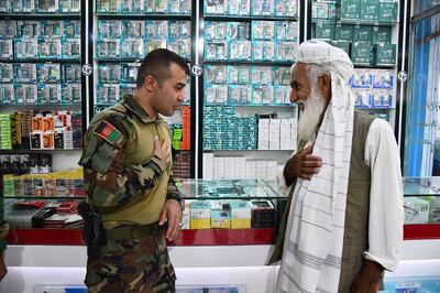 Gen Sami Sadat greets a man in the city of Zaranj in Nimruz province. AFP 