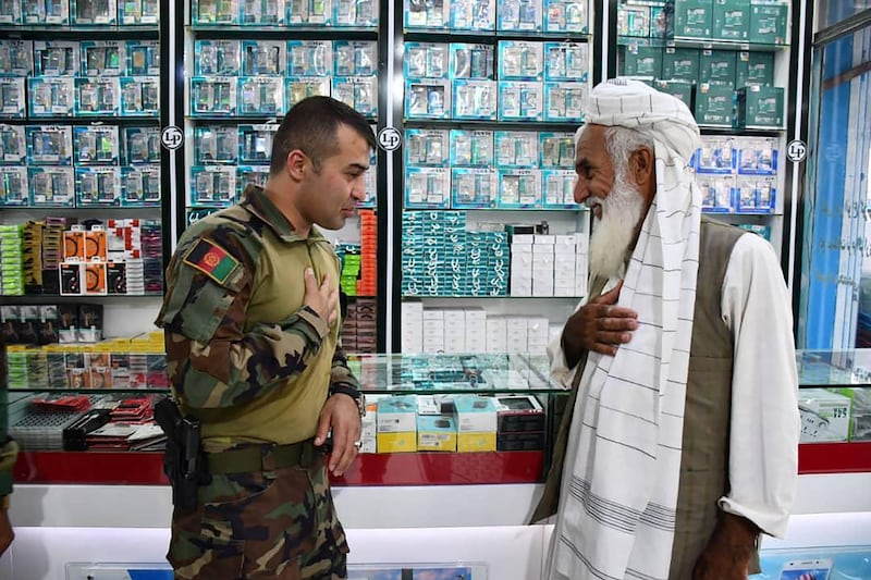 Lt Gen Sami Sadat, commander of the 215 Maiwand Afghan Army Corps, left, greets a man in the city of Zaranj in Nimruz province in August 2021. AFP