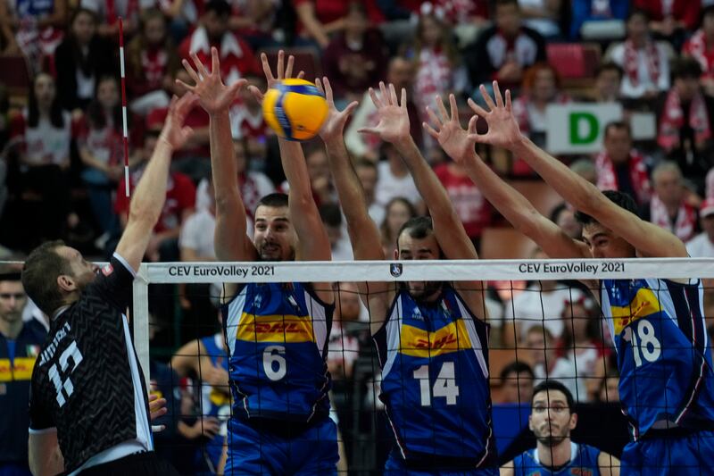 Slovenia's Tine Urnaut, left, spikes the ball past, left to right, Simone Giannelli, Gianluca Galassi and Alessandro Michieletto of Italy during the European Championship volleyball final at the Spodek Arena in Katowice, Poland, on Sunday, September 19. AP