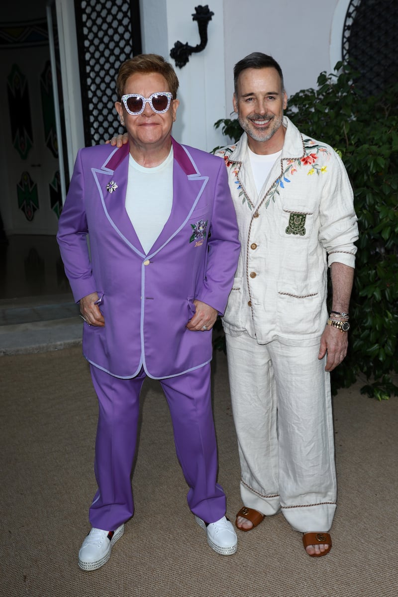 Elton John, in a lilac suit, and David Furnish attend the Midsummer Party to raise funds for the Elton John Aids Foundation in Antibes, France on July 24, 2019. Getty Images