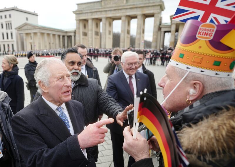 King Charles greets a fan wearing a crown at the Brandenburg Gate. AP