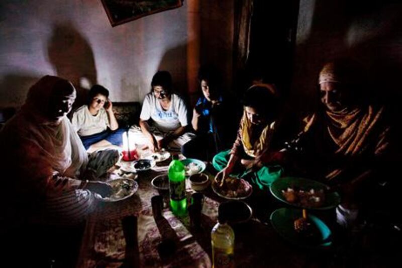 A Kashmiri Muslim family eats dinner after breaking their Ramadan fast during a regular load shedding in Srinagar, India, Wednesday, Aug. 1, 2012. Factories and workshops across India were up and running again Wednesday, a day after a major system collapse led to a second day of power outages and the worst blackout in history leaving an estimated 620 million people without electricity. (AP Photo/ Dar Yasin) *** Local Caption ***  India Power Outage.JPEG-0ae5e.jpg