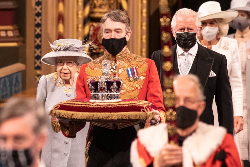 Queen Elizabeth, escorted by Prince Charles, follows the imperial state crown along the royal gallery during the state opening of Parliament at the House of Lords in May.