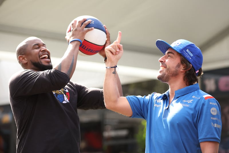 Alpine driver Fernando Alonso with  Harlem Globetrotters' Scooter ahead of the Australian Grand Prix. Reuters