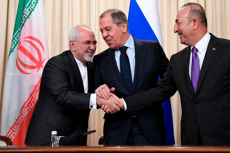 Russian Foreign Minister Sergei Lavrov (C), his Iranian counterpart Mohammad Javad Zarif (L) and Turkish Foreign Minister Mevlut Cavusoglu shake hands at the end of a joint press conference following their talks in Moscow on April 28, 2018. / AFP PHOTO / Alexander NEMENOV