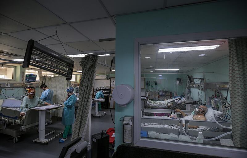 Members of the clinical staff wearing Personal Protective Equipment (PPE) care for a patient with coronavirus in the intensive care unit at the European Hospital, east of Rafah town, southern Gaza strip, 30 November 2020. The European Hospital, which has been classified as the Epidemiology Hospital since the start of the coronavirus in the Gaza Strip on 25 August 2020, has 334 infected cases under clinical care including 109 severe and critical cases. The production capacity of oxygen is 2,200 liters per minute, and there has become a large deficit after the increasing number of infections with Coronavirus.  EPA/MOHAMMED SABER