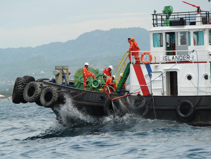 A boat sprays chemical despersal to contain an oil spill believed to be from a sunken ferry in Talisay town near Cebu City, central Philippines on August 18, 2013, two days after a ferry and a freighter collided. Philippine rescuers struggled in rough seas August 18, as they resumed a bleak search for 85 people missing in the country's latest ferry disaster, but insisted miracle survivor stories were possible.   AFP PHOTO/TED ALJIBE
 *** Local Caption ***  760959-01-08.jpg