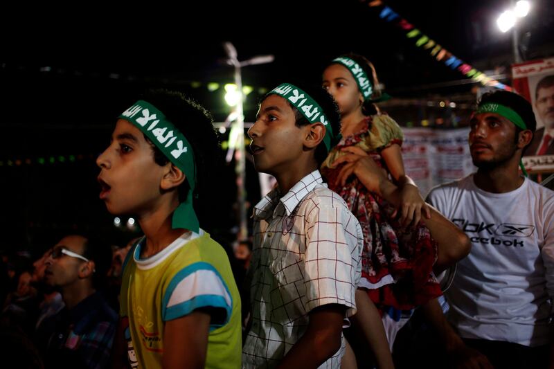 Supporters of Egypt's ousted President Mohammed Morsi chants slogans against Egyptian Defense Minister Gen. Abdel-Fattah el-Sissi at Nasr City, where protesters have installed a camp and hold daily rallies, in Cairo, Egypt, Sunday, July 28, 2013. Deadly clashes broke out during funerals of slain supporters of Egypt's ousted Islamist president Sunday, as the supreme leader of the Muslim Brotherhood urged his followers to stand fast after more than 80 of them were killed in weekend violence. The Arabic on the bandanas read, " No god but Allah and Mohammad is his prophet." (AP Photo/Hassan Ammar) *** Local Caption ***  Mideast Egypt.JPEG-0d9ed.jpg