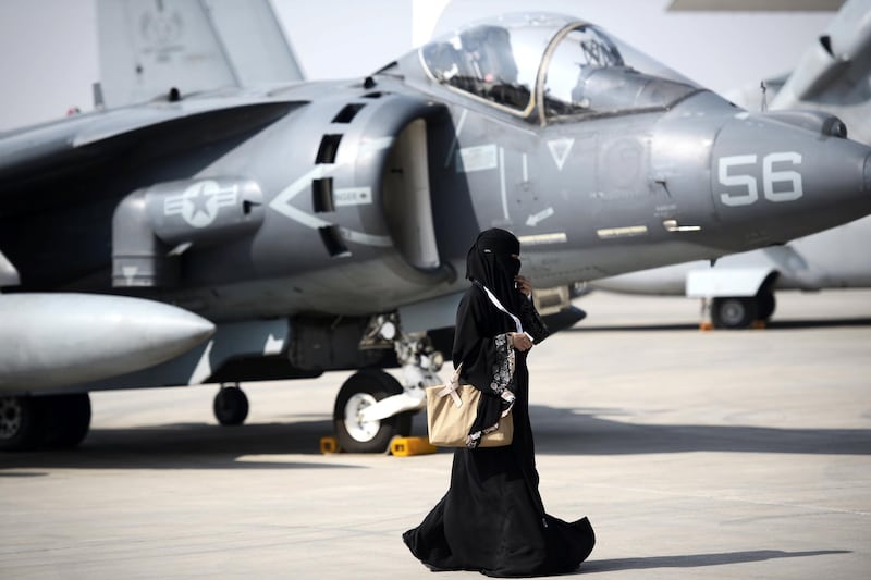 A Saudi woman walks past a US airplane during the opening of the Bahrain International Airshow 2016, in Sakhir, south of the capital Manama, on January 21, 2016. (Photo by MOHAMMED AL-SHAIKH / AFP)