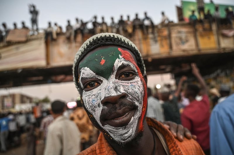 A Sudanese protestor poses with a Sudan national flag painted on his face during a protest outside the army complex in the capital Khartoum on April 20, 2019. Protest leaders are to hold talks on April 20 with Sudan's military rulers who have so far resisted calls to transfer power to a civilian administration, two leading figures in the protests told AFP. / AFP / OZAN KOSE
