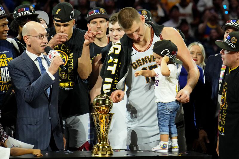 Denver Nuggets centre Nikola Jokic and his daughter point to the Bill Russell NBA Finals MVP Award trophy after winning the 2023 NBA Finals against the Miami Heat at Ball Arena. USA Today