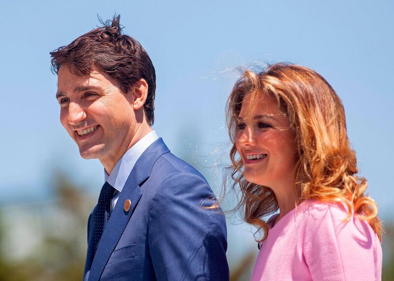 (FILES) In this file photo taken on June 08, 2018 Prime Minister of Canada Justin Trudeau and his wife Sophie Gregoire Trudeau arrive for a welcome ceremony for G7 leaders on the first day of the summit in La Malbaie, Quebec, Canada. Canadian Prime Minister Justin Trudeau and his wife announced they were self-isolating on March 12, 2020 as she undergoes tests for the new coronavirus after returning from a speaking engagement with "mild flu-like symptoms." Sophie Gregoire-Trudeau's symptoms have subsided since she recently got back from Britain, but as a precaution the prime minister "will spend the day in briefings, phone calls and virtual meetings from home," according to a statement. / AFP / GEOFF ROBINS
