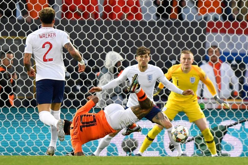 Netherlands' Memphis Depay attempts a shot at goal in front of Pickford and Stones. AP Photo