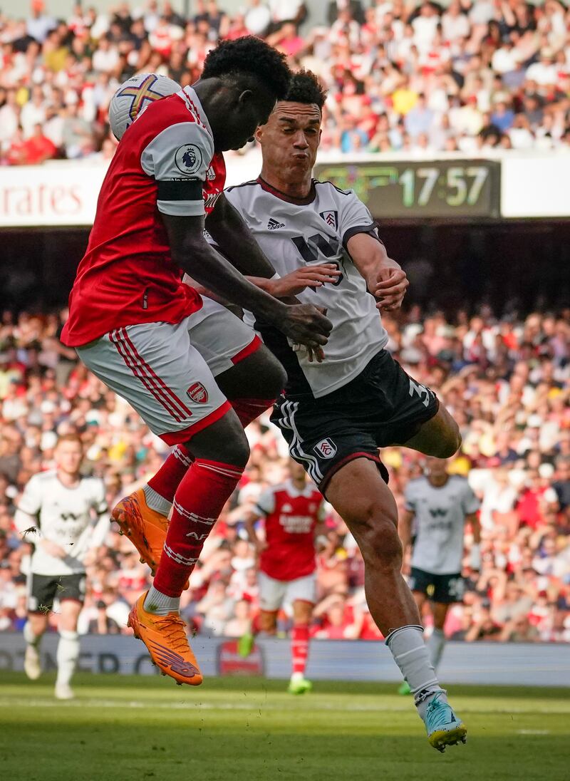 Arsenal's Bukayo Saka, left, challenges for the ball with Fulham's Antonee Robinson. AP