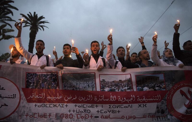 Moroccan schoolteachers hold candles as they protest against their current status in the capital Rabat. AFP
