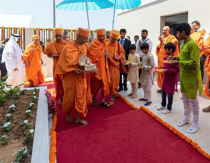 Children welcome Swamishri with flower petals. courtesy: BAPS