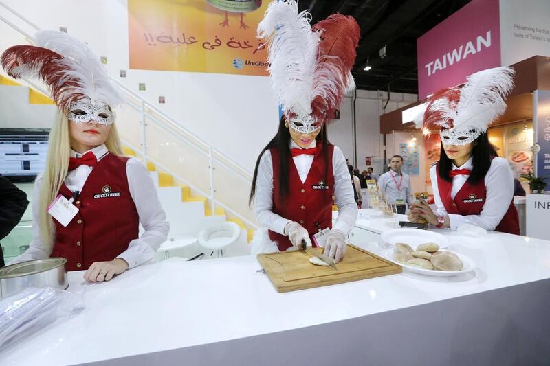Masked women prepare food for visitors at the Chicki Chunk showroom during the Gulfood exhibition at Dubai World Trade Centre. Jaime Puebla / The National Newspaper