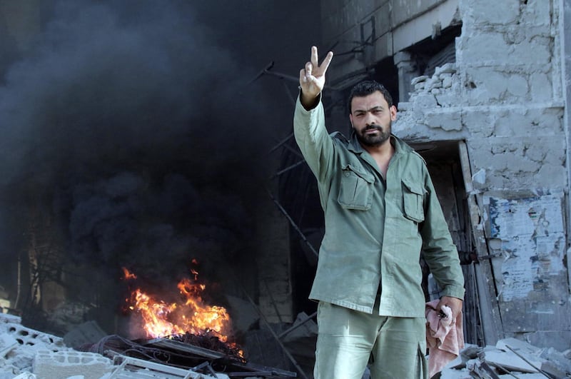 epaselect epa06754709 A Syrian soldier poses for the camera in al-Hajar al-Aswad neighborhood in south Damascus, Syria, 21 May 2018. According to reports, the Syrian army claims it has regained full control over Damascus' surrounding areas. State TV reports that the army cleared the area and the adjacent al-Yarmouk camp after killing large number of ISIS fighters.  EPA/YOUSSEF BADAWI