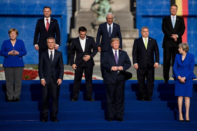 TOPSHOT - US President Donald Trump poses with Germany's Chancellor Angela Merkel (L), NATO Secretary General Jens Stoltenberg (3R), Britain's Prime Minister Theresa May (R) in a group photograph ahead of a working dinner at The Parc du Cinquantenaire - Jubelpark Park in Brussels on July 11, 2018, during the North Atlantic Treaty Organization (NATO) summit.  / AFP / Brendan Smialowski
