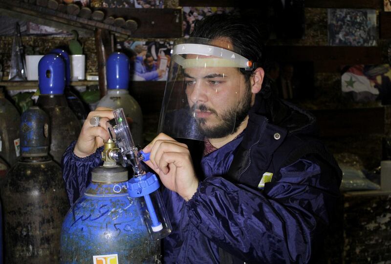 A volunteer adjusts an oxygen cylinder, to be delivered to people who suffer from coronavirus disease (COVID-19) and receive home care, in Damascus, Syria. Reuters