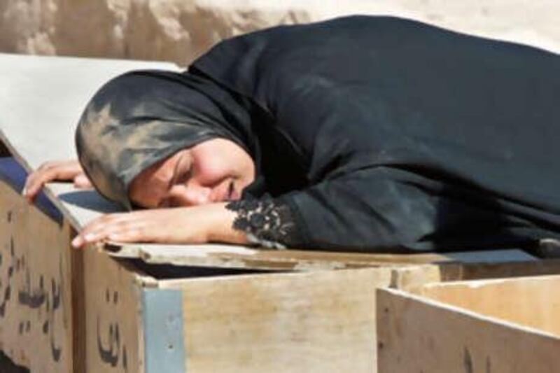 An Iraqi woman weeps over her son's coffin during his funeral in Najaf. The boy was killed by a roadside bomb in July.