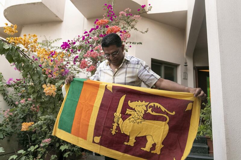 DUBAI, UNITED ARAB EMIRATES - NOVEMBER 7, 2018. 

Ajantha Premarathne holds up the Sri Lankan flag in his home.

(Photo by Reem Mohammed/The National)

Reporter: RAMOLA TALWAR
Section:  NA
