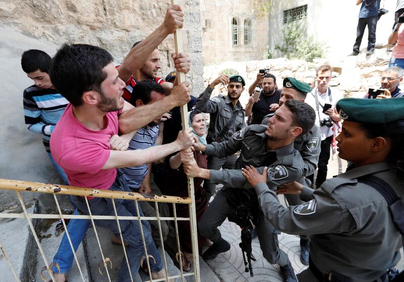 Israeli police officers scuffle with Palestinians as the police try to detain them in the West Bank city of Hebron. Reuters