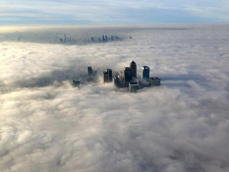 The Canary Wharf financial district and central London emerge from morning fog in London. Metropolitan Police / Reuters