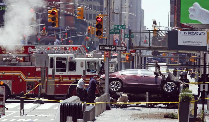 Investigators examine a car that ploughed through crowds of pedestrians before stopping on the corner of Broadway and 45th Street in New York’s Times Square on May 18, 2017. Seth Wenig / AP Photo