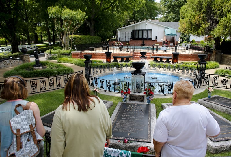 Visitors pass the graves of Elvis Presley, his parents and stillborn twin brother during a tour of Graceland in Memphis, Tennessee. Reuters