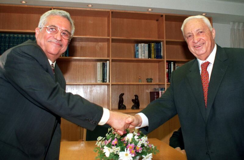 Mahmoud Abbas (L), the Palestinian negotiator better known as Abu Mazen, and Israeli Foreign Minister Ariel Sharon turn to the cameras and smile as they shake hands at the start of their meeting in Sharon's office November 18. The two met to review the work of all the Israeli-Palestinian peace committees and to set a date for the resumption of final status talks.

DPS/KM