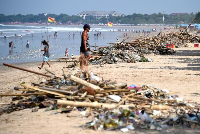 A tourist walking past debris washed up on Kuta beach near Denpasar on Indonesia's resort island of Bali. Indonesia is facing a plastic waste crisis driven by years of rapid economic growth. Sonny Tumbelaka/AFP