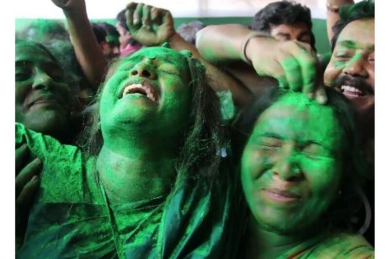 Trinamool Congress Party supporters, covered in green paint to show their party allegiance, celebrate outside the residence of the leader Mamata Banerjee in Kolkata yesterday, after she crushed the ruling Communist Party of India (Marxist) at elections, taking 200 seats to the latter's 70. Jayanta Shaw / AFP