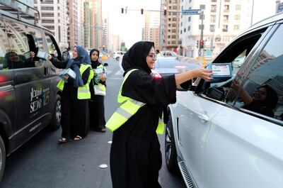 ABU DHABI , UNITED ARAB EMIRATES , MAY 29 – 2018 :- Volunteers giving iftar boxes to the motorist at the Al Wahda Mall signal in Abu Dhabi.  ( Pawan Singh / The National )  For News. Story by Omnia Al Saleh