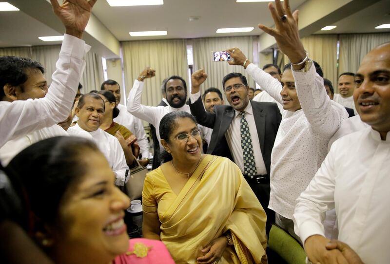 Sri Lankan lawmakers who are demanding the convening of the Parliament cheer after a meeting with the speaker of the parliament in Colombo, Sri Lanka, Friday, Nov. 2, 2018. (AP Photo/Eranga Jayawardena)