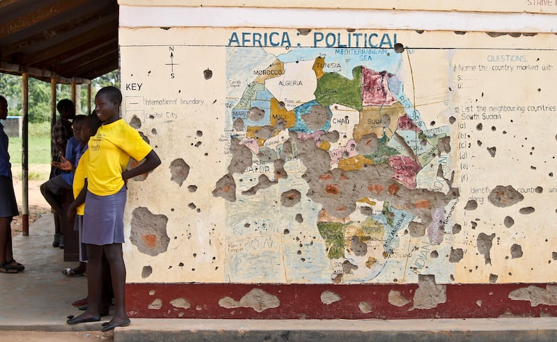 FILE - In this Nov. 15, 2016 file photo, students line up outside a classroom with a map of Africa on its wall, in Yei, in southern South Sudan. The United States is poised to permanently lift sanctions on Sudan, U.S. officials said Oct. 5, 2017, recognizing the long-estranged country's progress on human rights and counterterrorism after decades of war and abuses. The Trump administration will complete a process that former President Barack Obama started in January, when he temporarily lifted the penalties. (AP Photo/Justin Lynch, File)