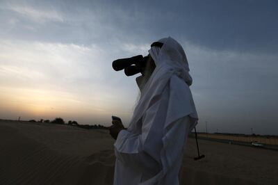 A man looks for the new crescent moon to indicate the start of a new Islamic month. Pawan Singh / The National