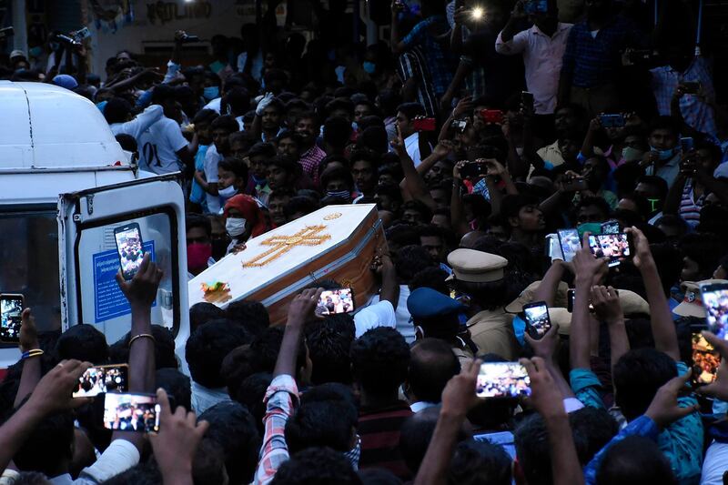 In this picture taken on June 26, 2020, residents gather as they carry the coffin of Jayaraj, 58, and son Bennicks Immanuel, 31, allegedly tortured at the hands of police in Sathankulam, Thoothukudi district in the Indian state of Tamil Nadu. The deaths of a father and son from alleged torture at the hands of police have sparked outrage across India, with many drawing parallels with the killing of George Floyd in the United States. / AFP / STR
