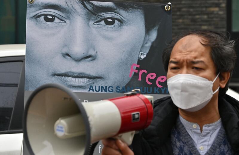 A protester shouts slogans next to a banner showing a picture of Aung San Suu Kyi during a demonstration near the military office of the Myanmar embassy in Seoul.  AFP