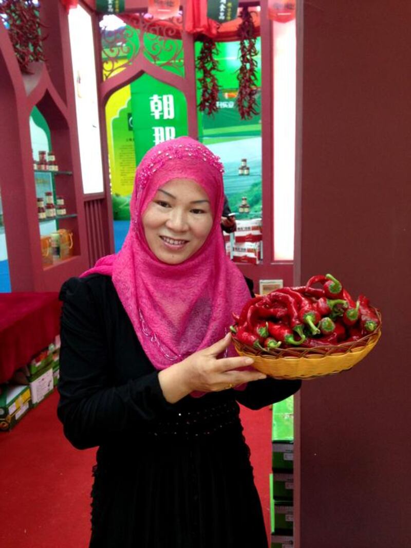 Ma Chengming holding a basket of chilies. Photo by Clifford Coonan