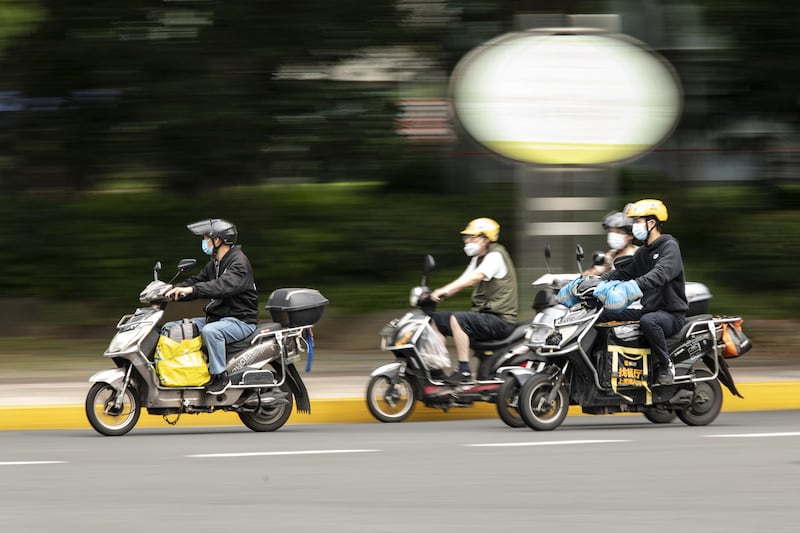 Motorcyclists travel through an intersection. Bloomberg