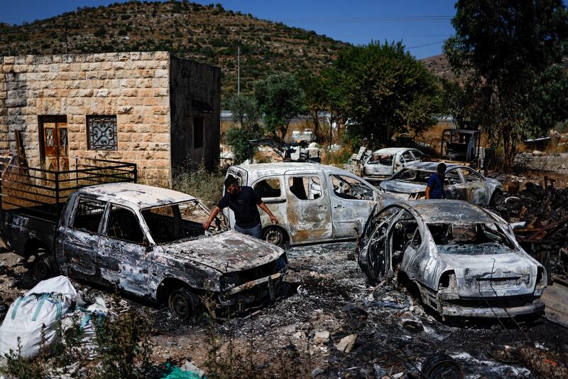 Palestinians check burnt vehicles after Israeli settlers attack near Ramallah in the occupied West Bank. Reuters