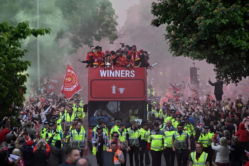 Reds players wave from an open-top bus during a parade through the streets of Liverpool. AFP